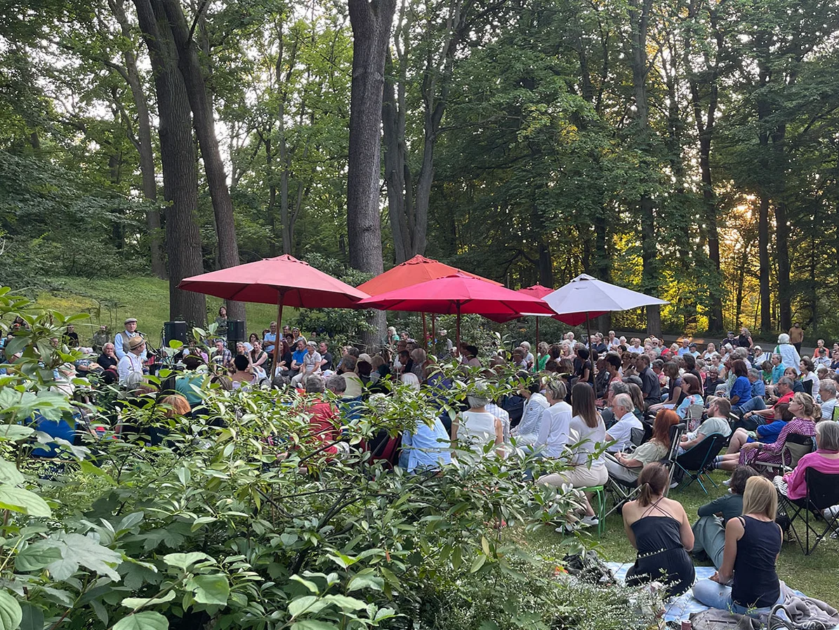 Publikum bei einer Lesung auf Decken und Klappstühlen im Stadtpark Fürth