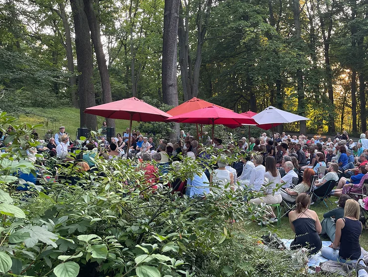 Publikum bei einer Lesung auf Decken und Klappstühlen im Stadtpark Fürth