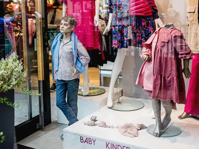 Schaufenster mit Kindermode und einer Schaufensterpuppe.